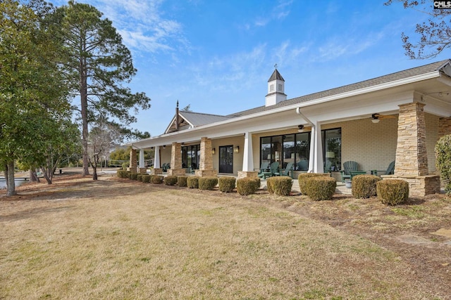 back of house featuring ceiling fan, a yard, and a porch