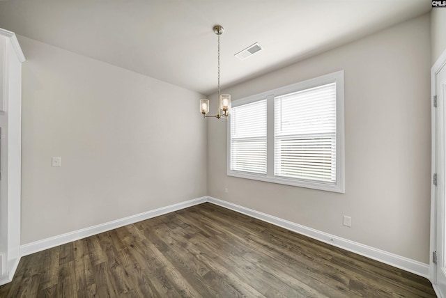 unfurnished room with dark wood-type flooring and an inviting chandelier