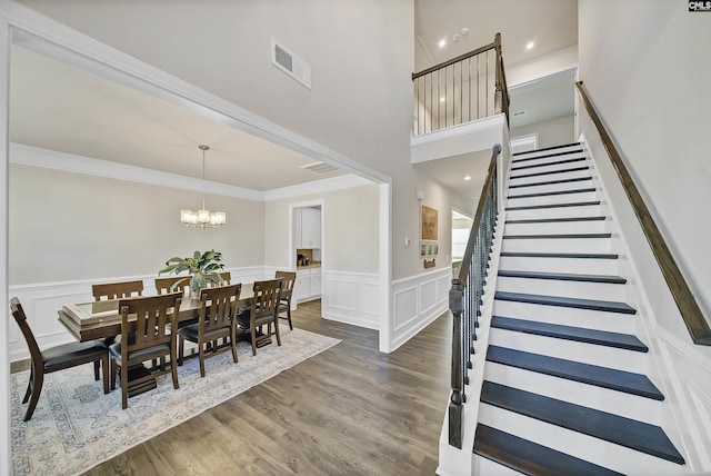 dining space featuring an inviting chandelier, ornamental molding, and dark hardwood / wood-style flooring