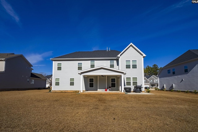 back of property featuring a patio area and a lawn