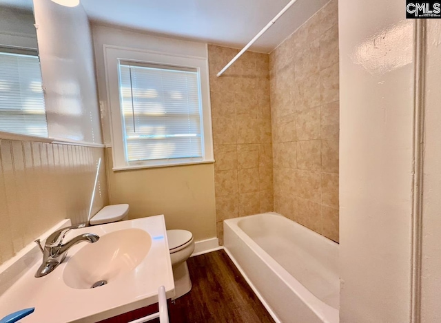 full bathroom with vanity, hardwood / wood-style floors, tiled shower / bath combo, and toilet