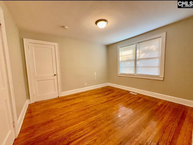 spare room with hardwood / wood-style floors