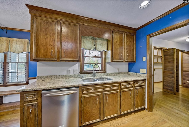 kitchen featuring sink, crown molding, light hardwood / wood-style flooring, dishwasher, and light stone countertops