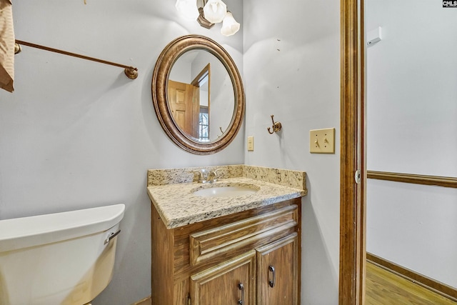 bathroom featuring vanity, hardwood / wood-style flooring, and toilet