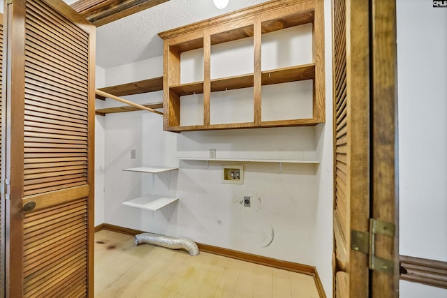 washroom with hookup for an electric dryer, hookup for a washing machine, and a textured ceiling