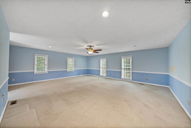 spare room with ceiling fan and carpet