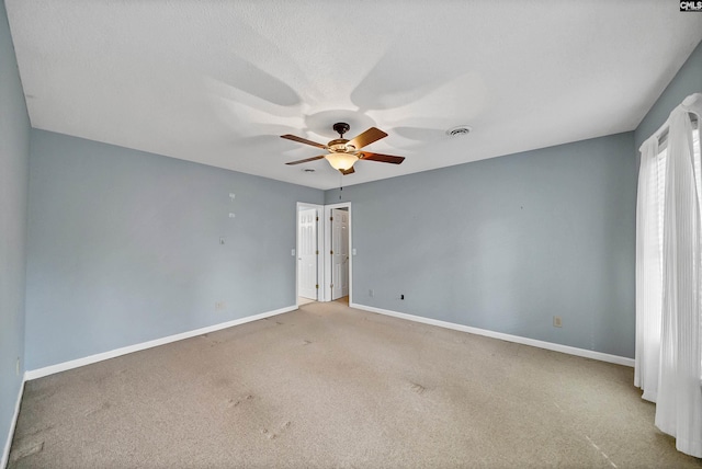 empty room featuring ceiling fan, carpet, and a textured ceiling