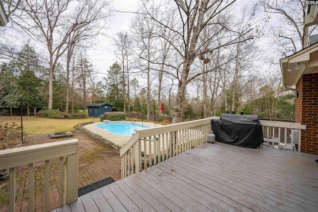 deck with a shed and a grill