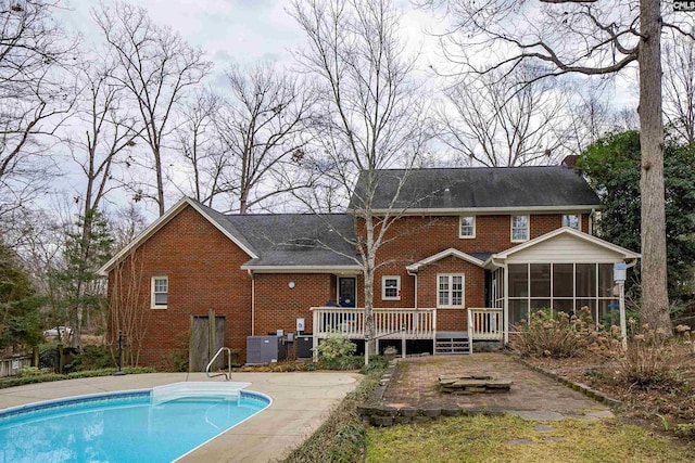 rear view of house featuring a swimming pool side deck, a sunroom, and central air condition unit