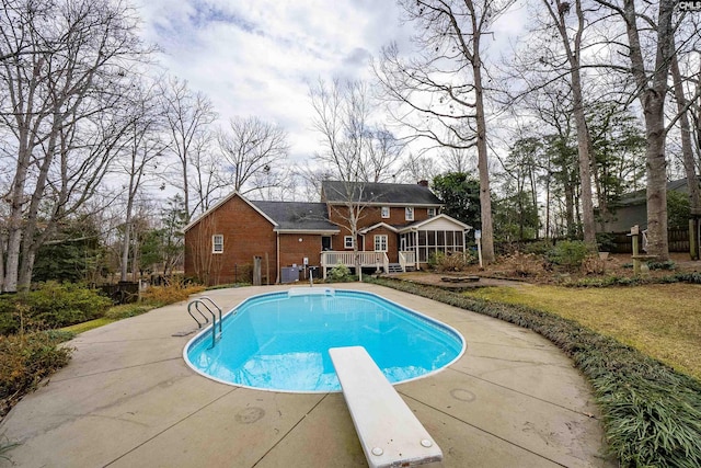 view of pool featuring a sunroom and a diving board