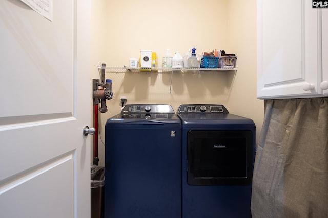 laundry room featuring washer and clothes dryer and cabinets