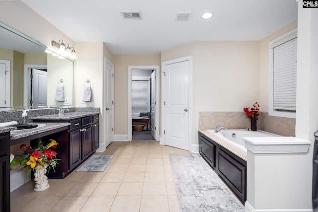 bathroom featuring vanity, tile patterned floors, and a bathing tub