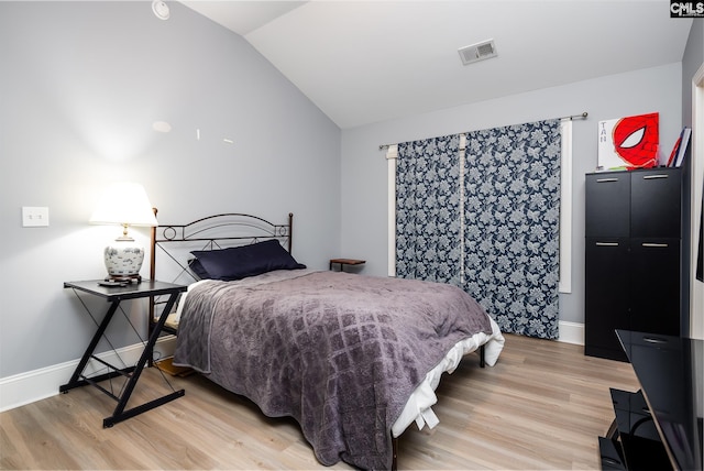 bedroom featuring lofted ceiling and light wood-type flooring