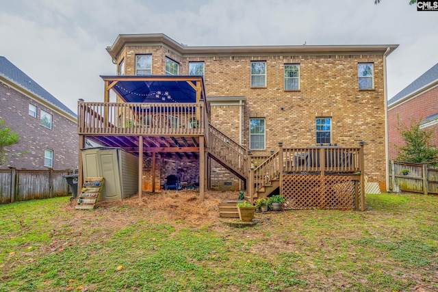 back of property featuring a wooden deck, a yard, and a storage shed