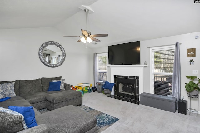 carpeted living room with ceiling fan, a fireplace, and vaulted ceiling