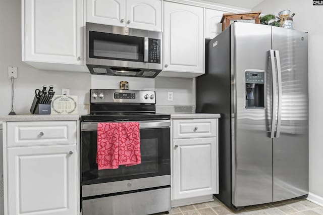 kitchen featuring stainless steel appliances and white cabinetry