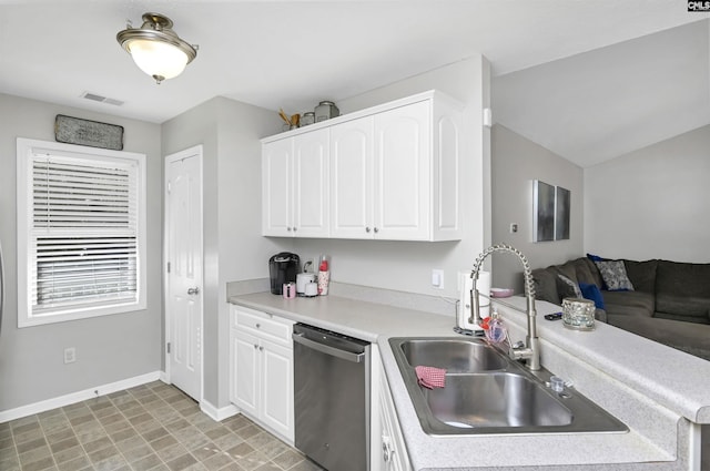 kitchen with dishwasher, vaulted ceiling, sink, and white cabinets