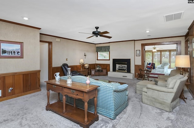 carpeted living room with ceiling fan, ornamental molding, and a brick fireplace