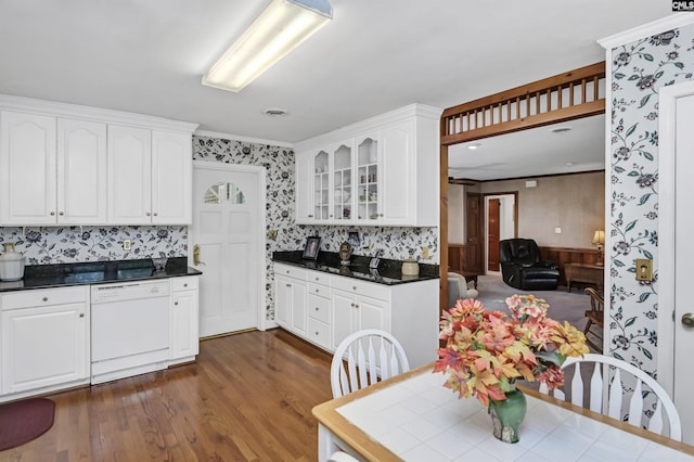 kitchen with white dishwasher, white cabinetry, dark wood-type flooring, and decorative backsplash