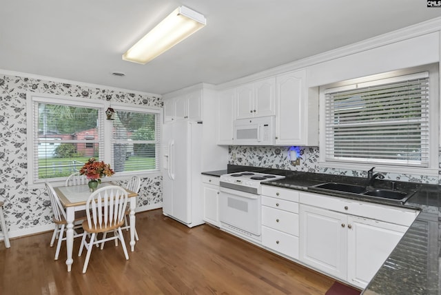 kitchen with dark hardwood / wood-style floors, white cabinetry, sink, dark stone counters, and white appliances