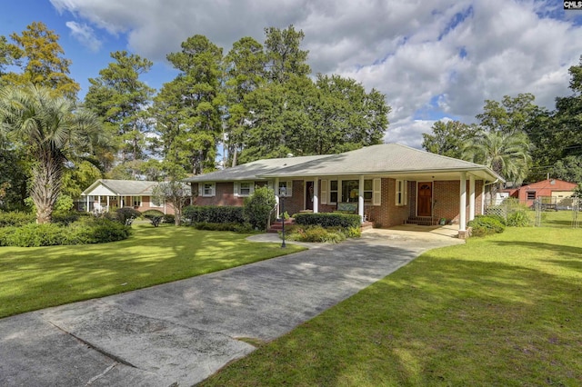 ranch-style home featuring covered porch and a front yard