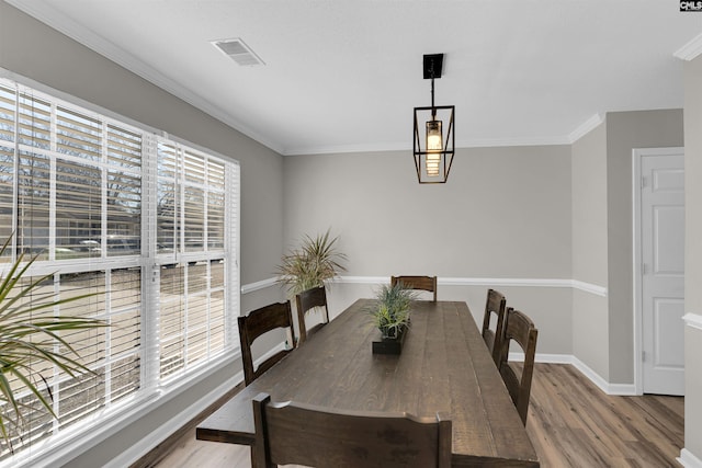 dining area featuring wood-type flooring and ornamental molding