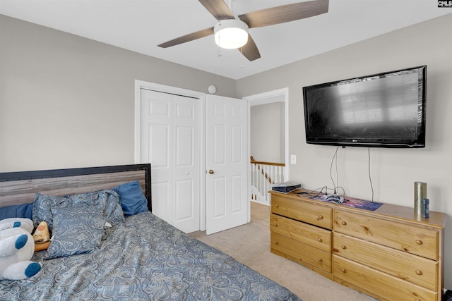 bedroom with ceiling fan, a closet, and light carpet