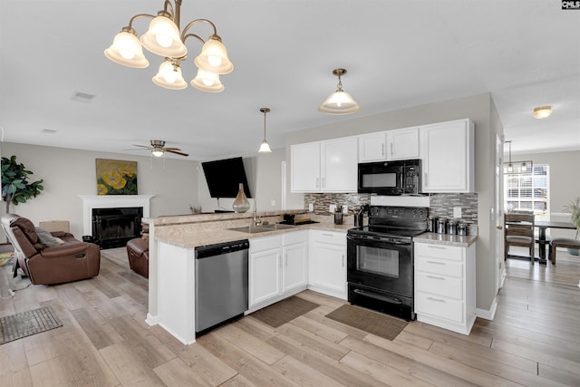 kitchen featuring white cabinetry, tasteful backsplash, hanging light fixtures, and black appliances