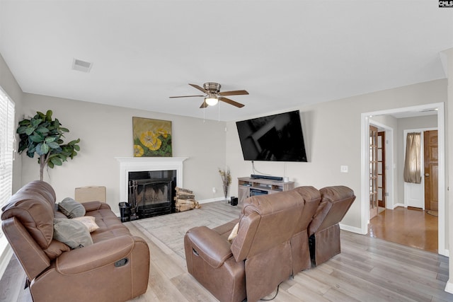 living room with ceiling fan and light hardwood / wood-style flooring