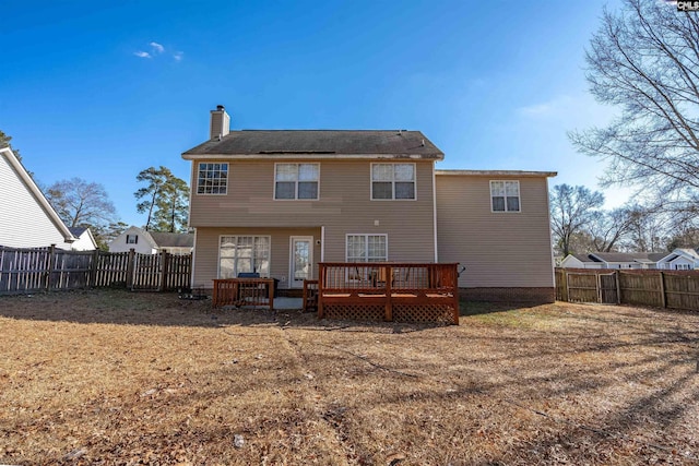 back of house featuring a wooden deck and a yard