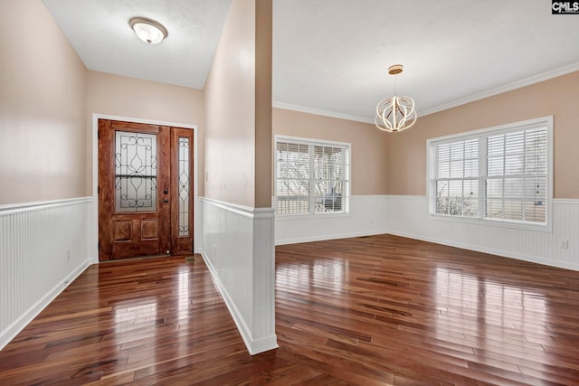 entrance foyer featuring dark wood-type flooring and an inviting chandelier