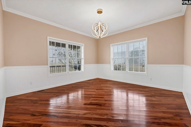 unfurnished dining area with a notable chandelier, dark wood-type flooring, and ornamental molding