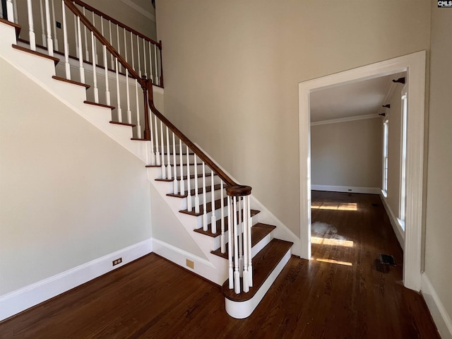 stairs with ornamental molding and hardwood / wood-style floors