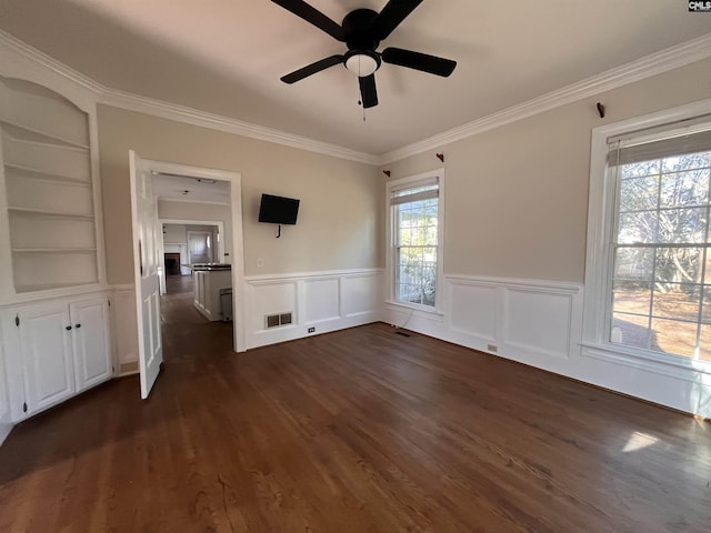 spare room featuring built in shelves, ceiling fan, ornamental molding, and dark hardwood / wood-style floors