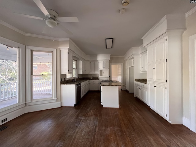 kitchen featuring dishwashing machine, crown molding, white cabinetry, a center island, and dark hardwood / wood-style flooring