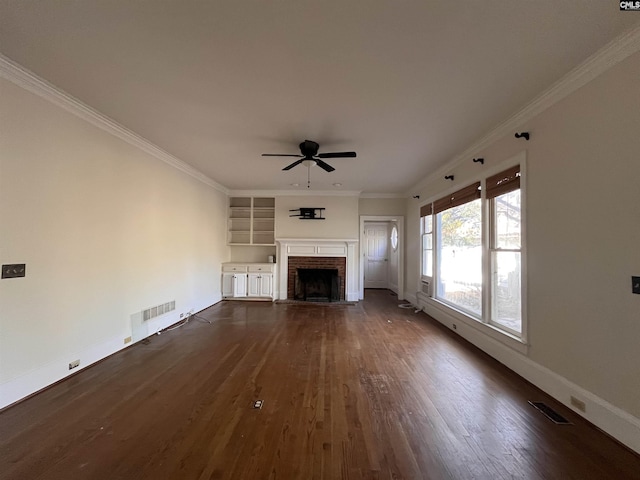 unfurnished living room featuring ornamental molding, a brick fireplace, dark hardwood / wood-style floors, and ceiling fan