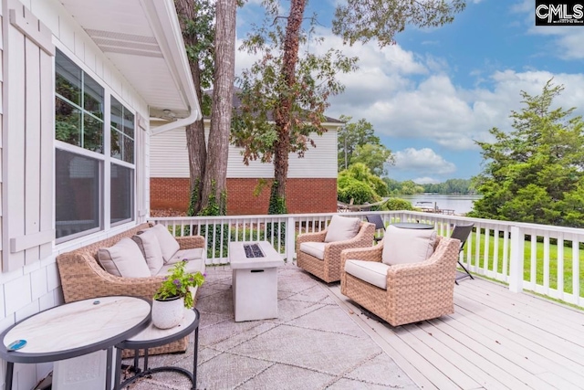 wooden deck featuring a water view and an outdoor living space with a fire pit