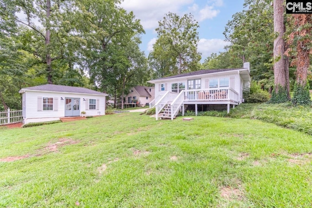 rear view of house with a yard and a deck