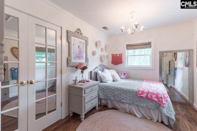 bedroom featuring an inviting chandelier, dark wood-type flooring, ornamental molding, and french doors