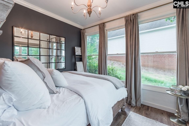 bedroom featuring hardwood / wood-style floors, ornamental molding, and a chandelier