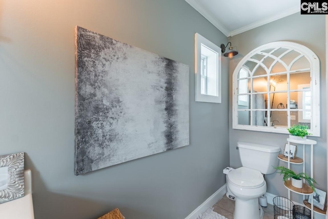 bathroom featuring tile patterned flooring, crown molding, and toilet