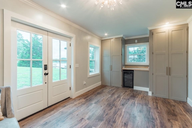 doorway to outside with wine cooler, wood-type flooring, ornamental molding, and french doors