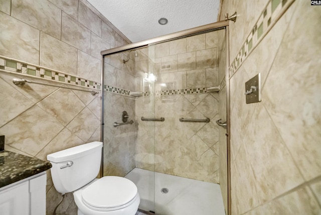 bathroom featuring vanity, an enclosed shower, a textured ceiling, and toilet