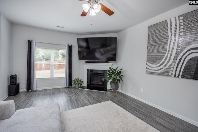 living room featuring ceiling fan and dark hardwood / wood-style floors