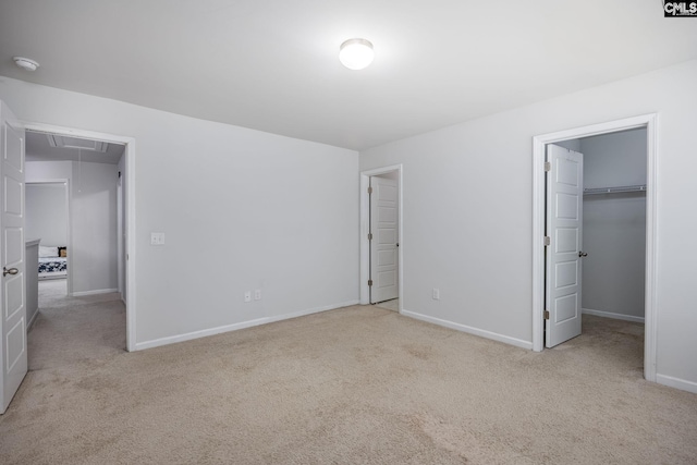 unfurnished bedroom with a spacious closet and light carpet