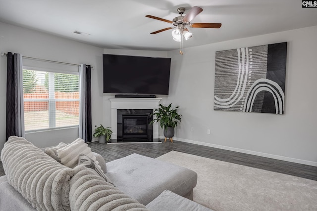 living room featuring ceiling fan, wood-type flooring, and a premium fireplace