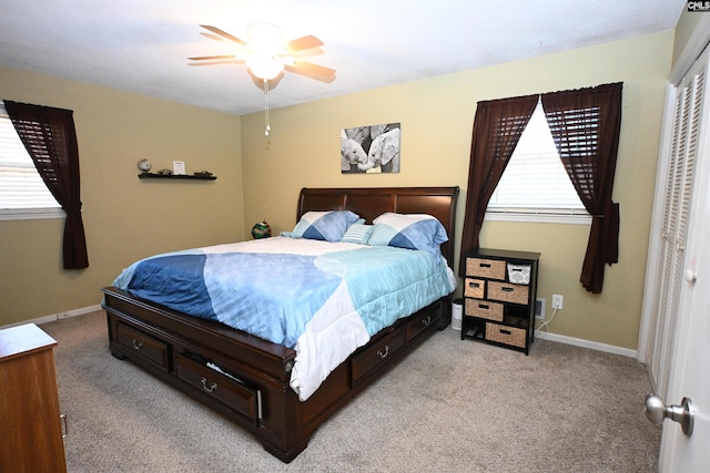 carpeted bedroom featuring multiple windows, a closet, and ceiling fan