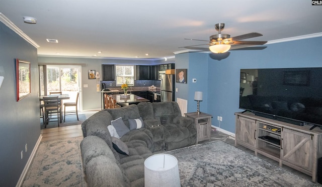 living room with crown molding and ceiling fan