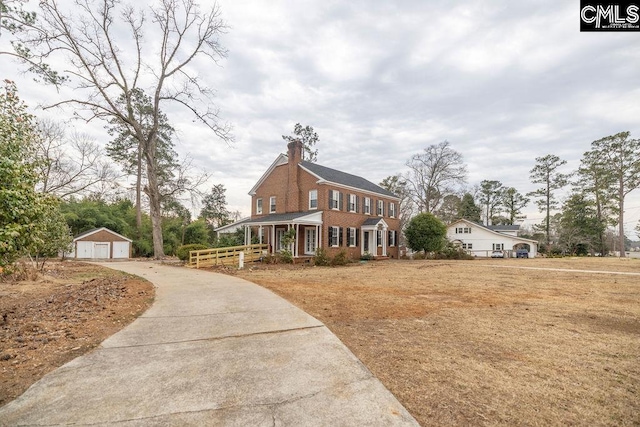 view of front facade with a garage, an outdoor structure, and covered porch