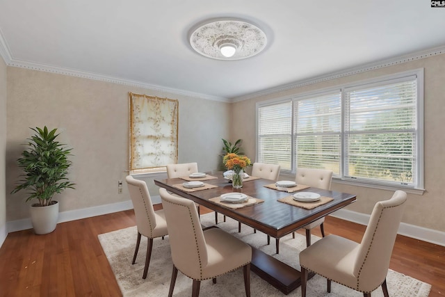 dining space with hardwood / wood-style floors and crown molding